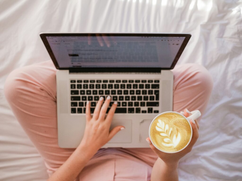 Checking email on a laptop with a morning latte