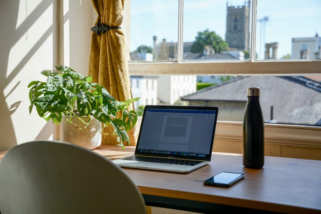 A laptop on a sunny home-office desk, ready for writing