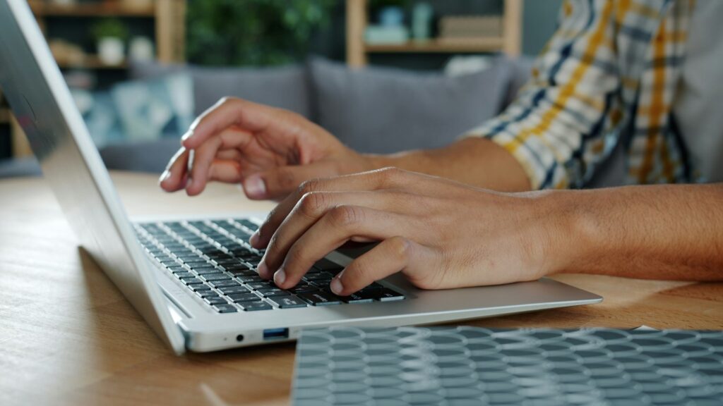 Hands typing an article draft on a laptop